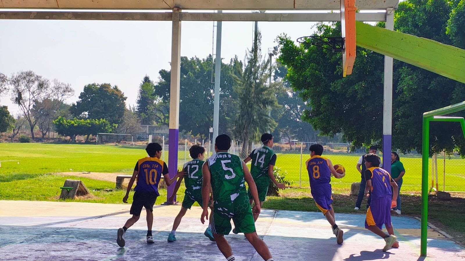 Partido de básquetbol entre estudiantes en la cancha del plantel